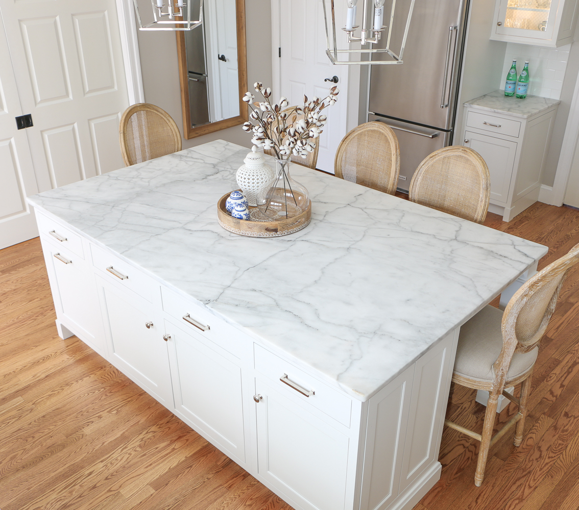 Top view of Carrara marble kitchen island and cane back counter stools