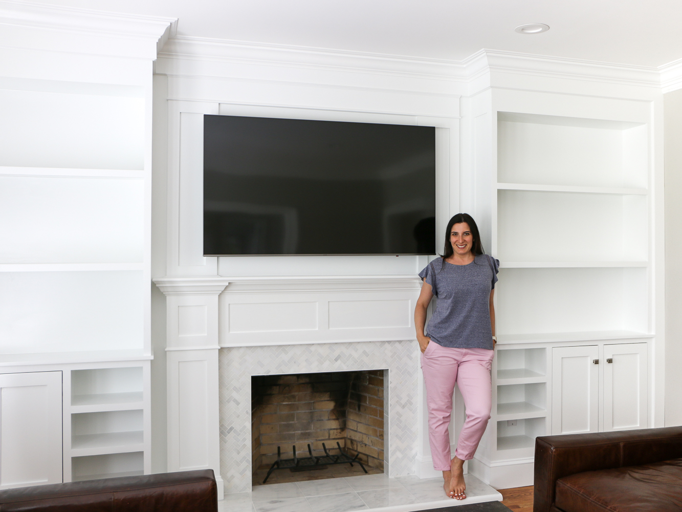 Stefana Silber in front of white marble fireplace and builtin shelves