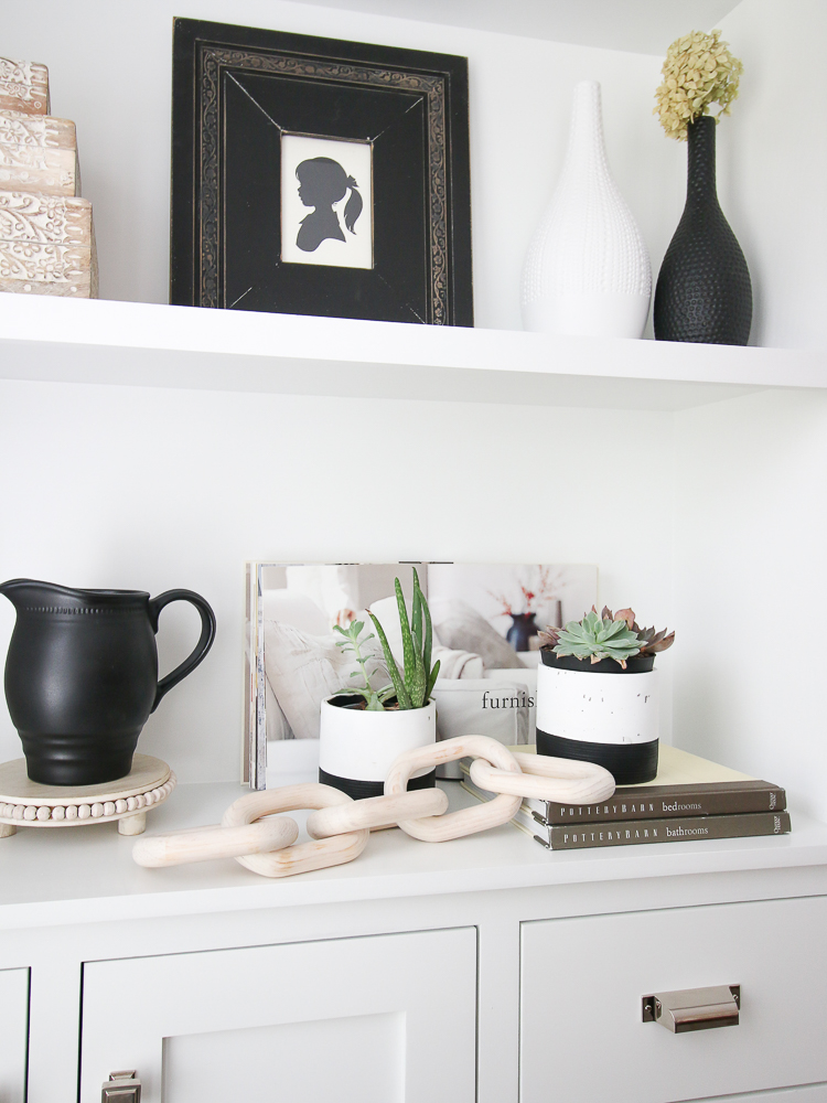 builtin shelves with black, white, and wooden decorative objects