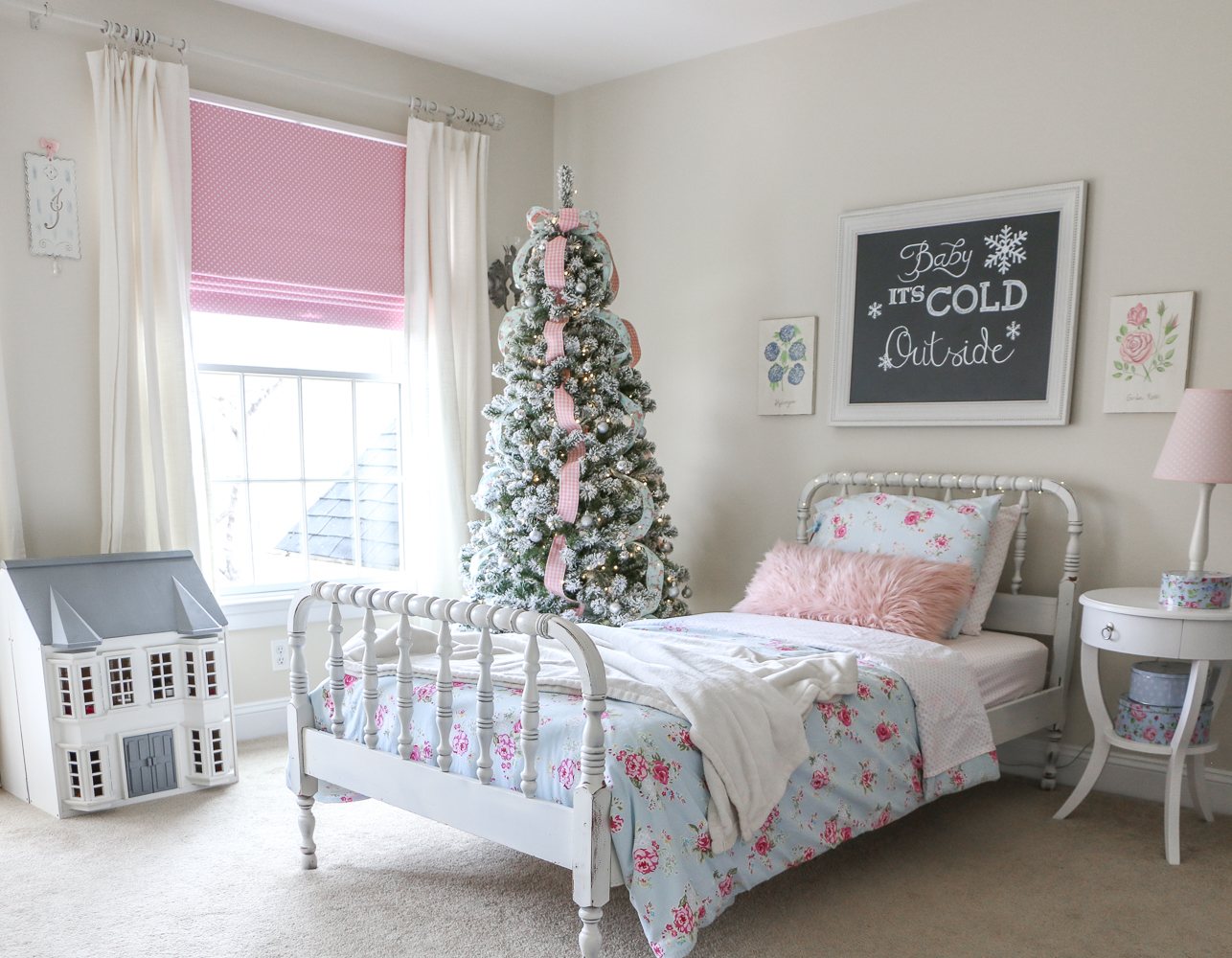 pink and blue girl's room decorated with flocked Christmas tree, pink and blue ribbon, white spindle bed, dollhouse
