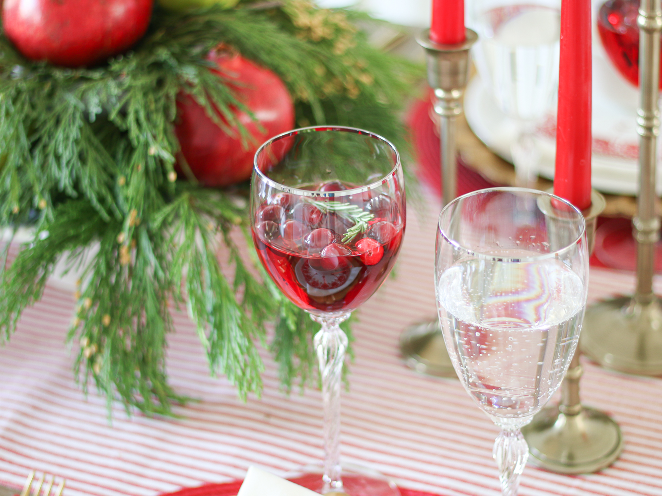 Close-up of drinkware on Christmas tablescape, crystal glasses with holiday cocktail, holiday entertaining, Christmas greenery
