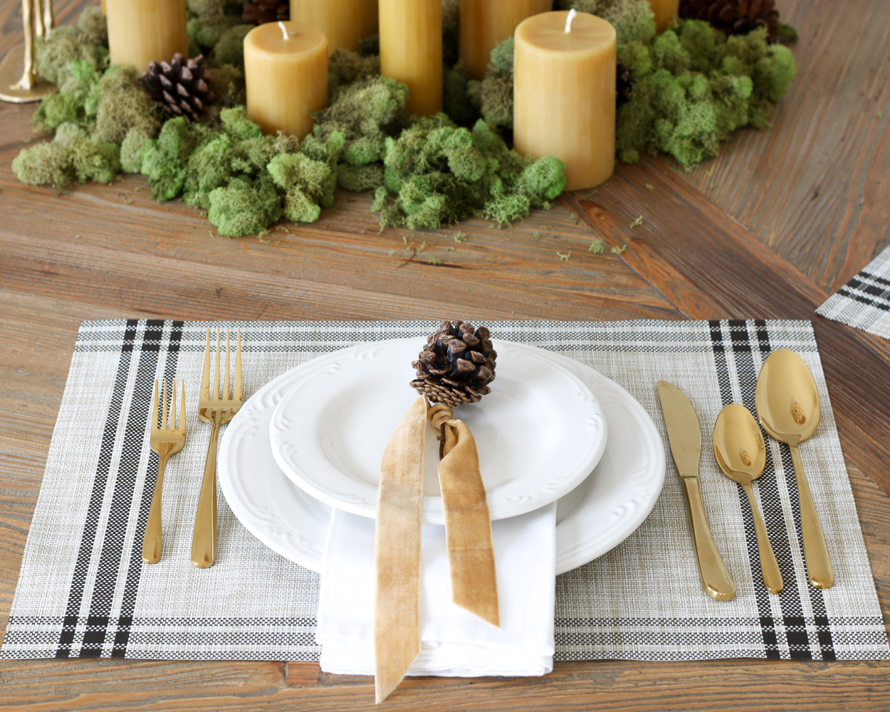 Simple and classic Christmas dining room with minimalist Table Setting, gold flatware, white dishes, plaid placemat