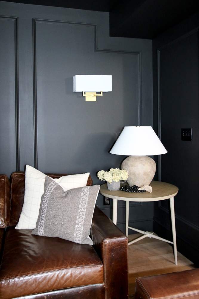 paint a room all black, leather sofa, round side table, ceramic table lamp