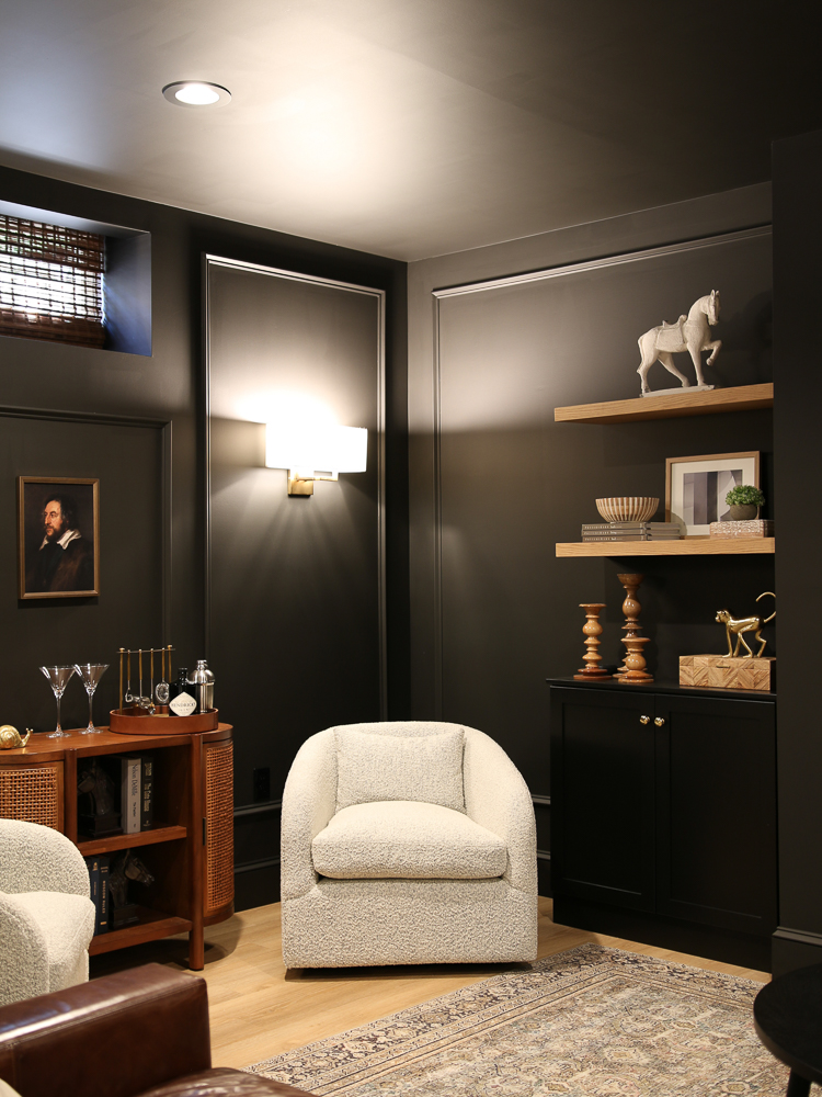 paint a room all black, floating shelves, wall sconce, boucle swivel chair, shelf decor, bar cart 