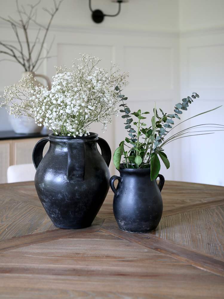 round wood dining table, black ceramic vases