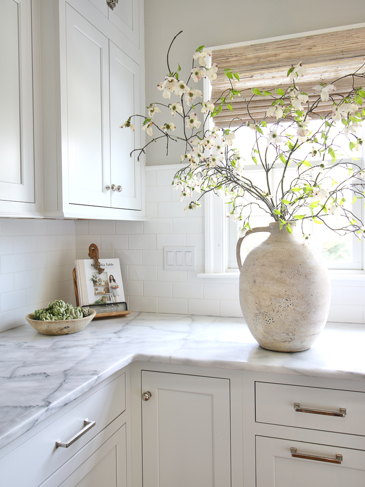 artisan vases, white kitchen, woven roman shade