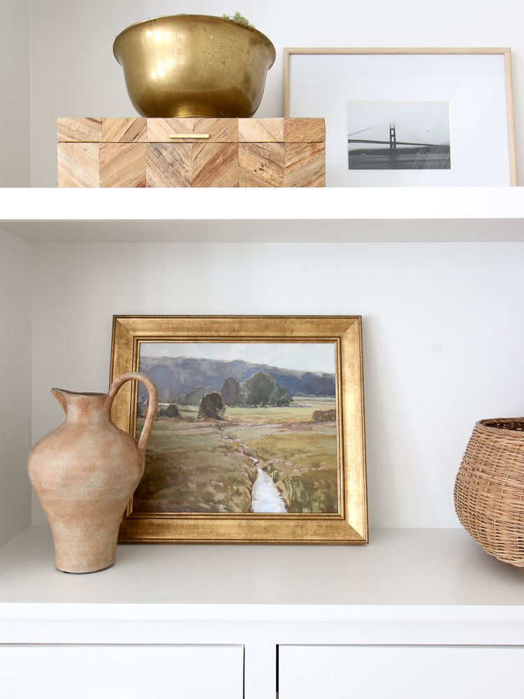 open shelf, wooden display box, ceramic vases, landscape framed art