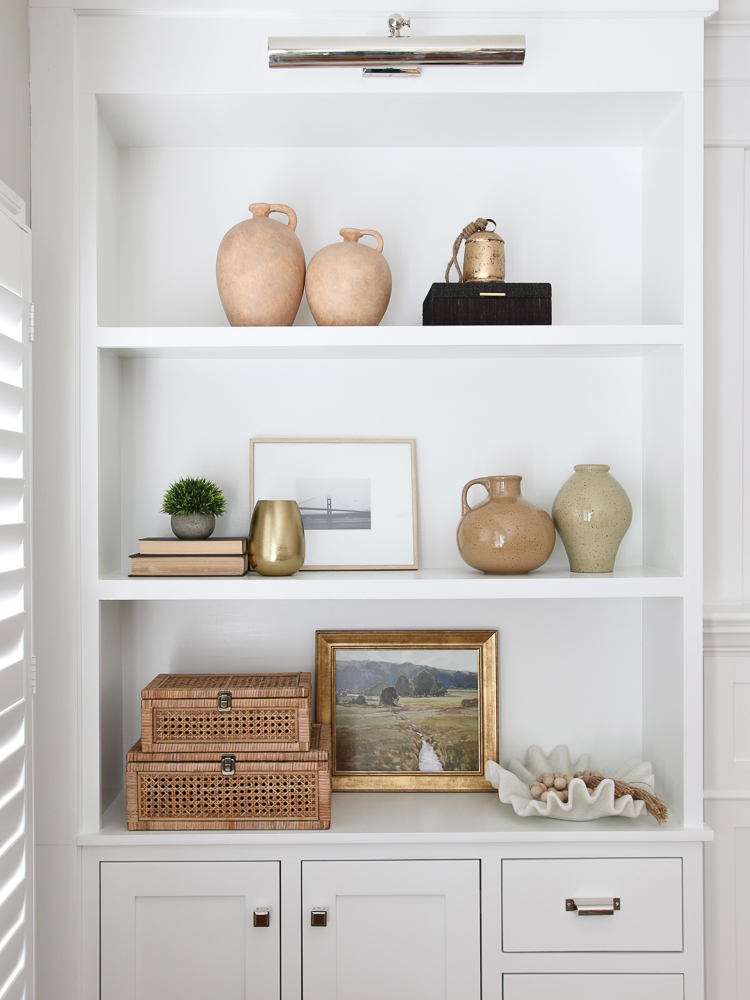 open shelf, rattan display boxes, ceramic vases, landscape framed art