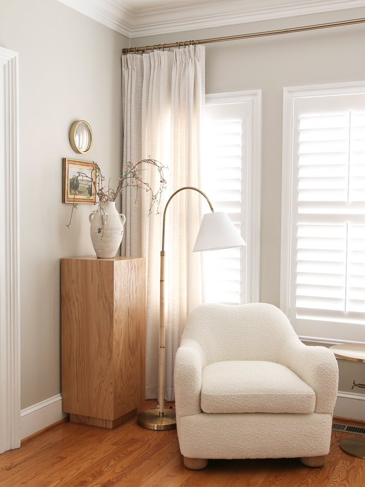 cozy corner of living room near window, white boucle chair and gooseneck lamp