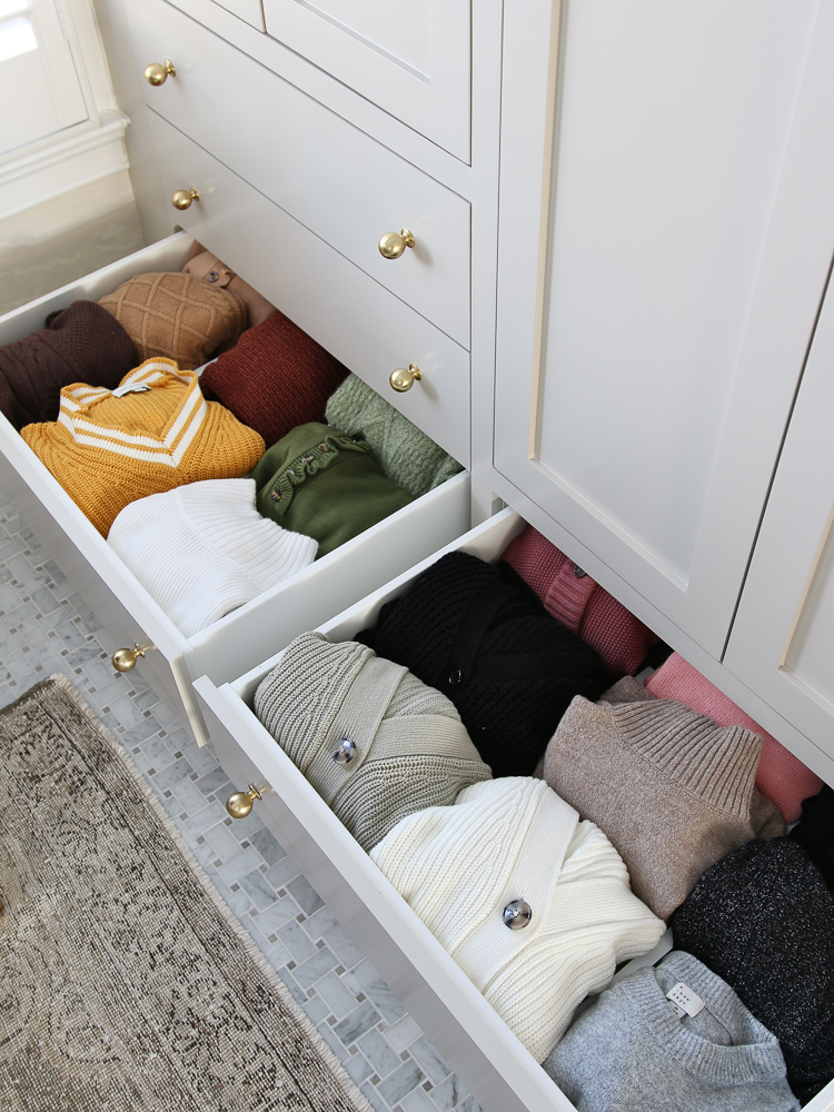 open drawers with multiple sweaters organized with expandable drawer dividers, closet organization hacks