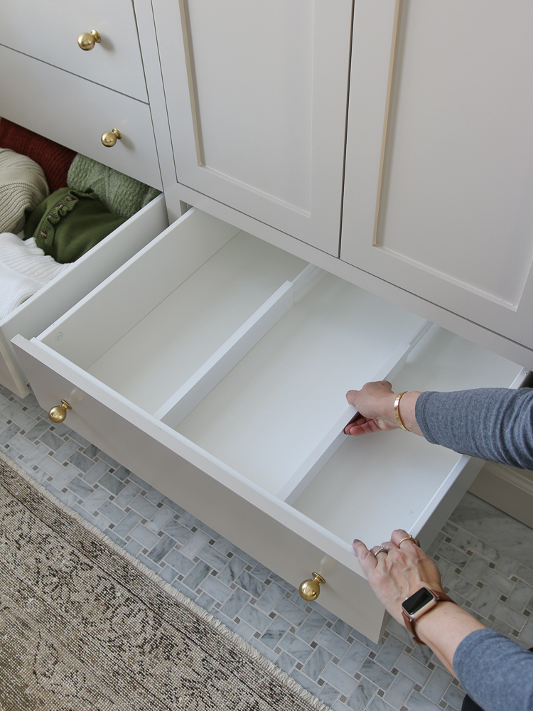 person installing expandable drawer divider in empty drawer