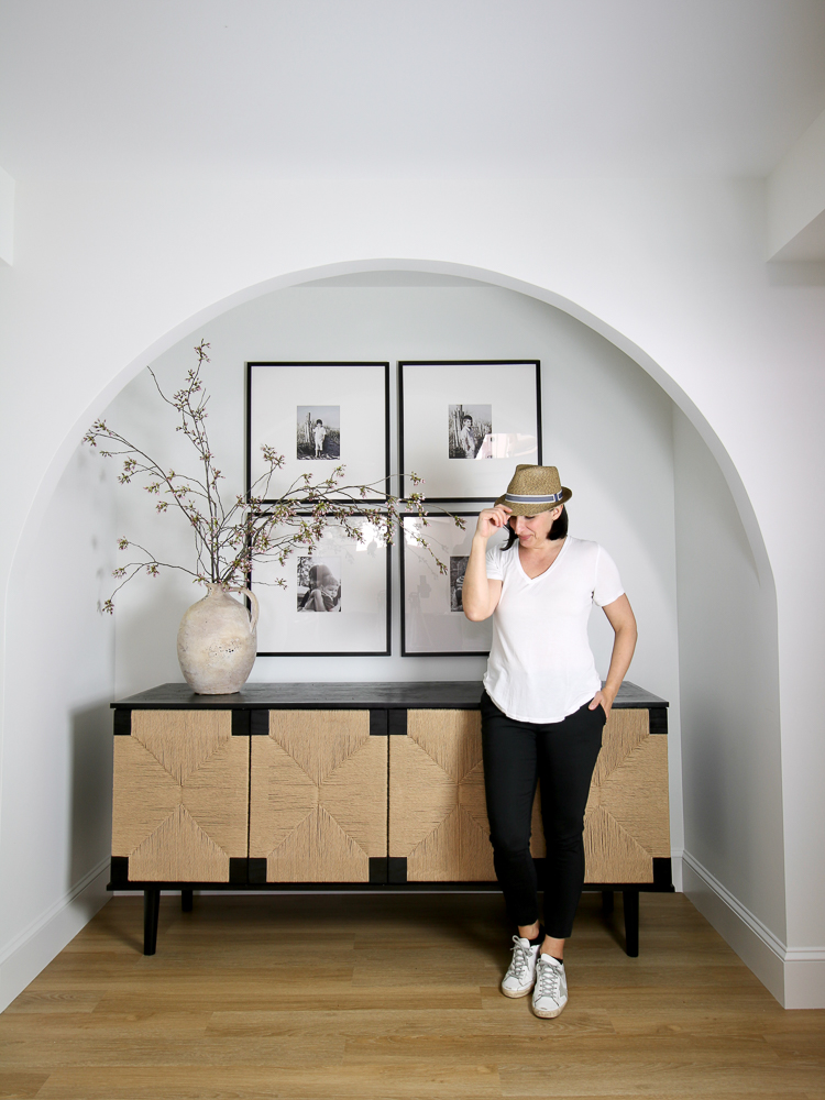 Stefana Silber in front of woven door cabinet and photo gallery wall 