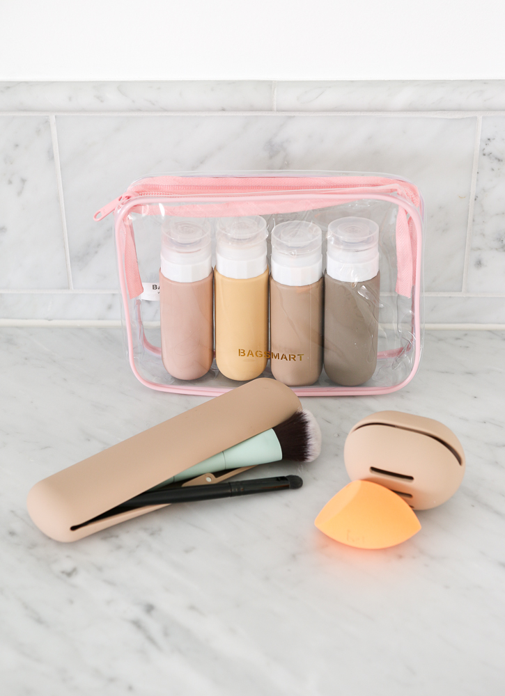 display of travel essentials on bathroom vanity, silicone makeup brush and sponge holder, toiletry bag with silicone travel bottles