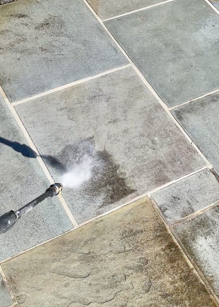 demonstration of how power washer cleans patio stones