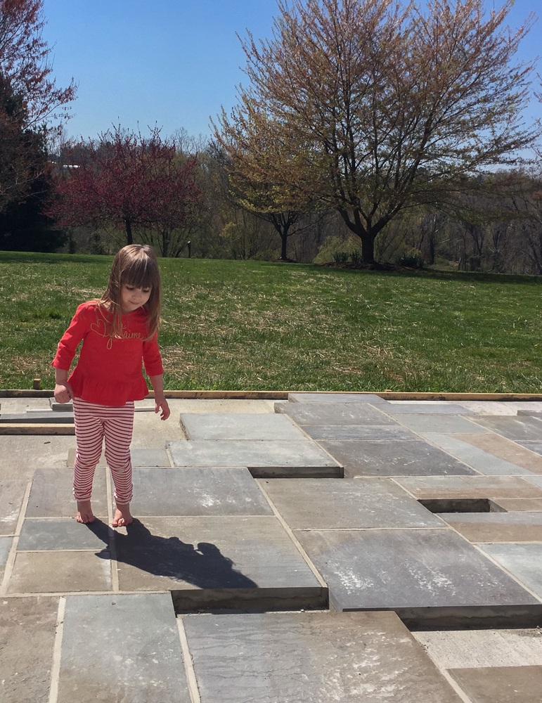 young girl walking on semi-completed patio