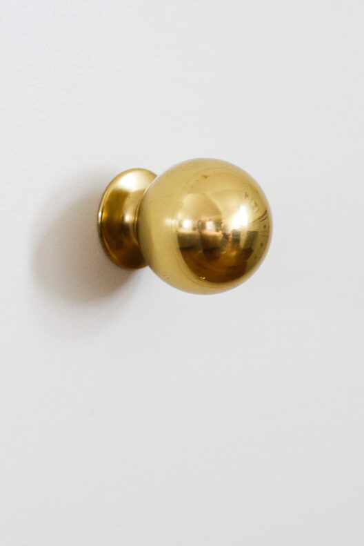 close up of round brass cabinet knob