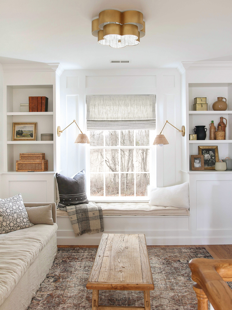 white builtins with window bench , sconces, shelf decor