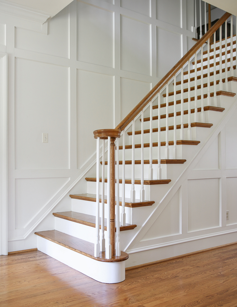 stairway with wall molding, white walls and hardwood floors showing how to customize a cookie cutter home