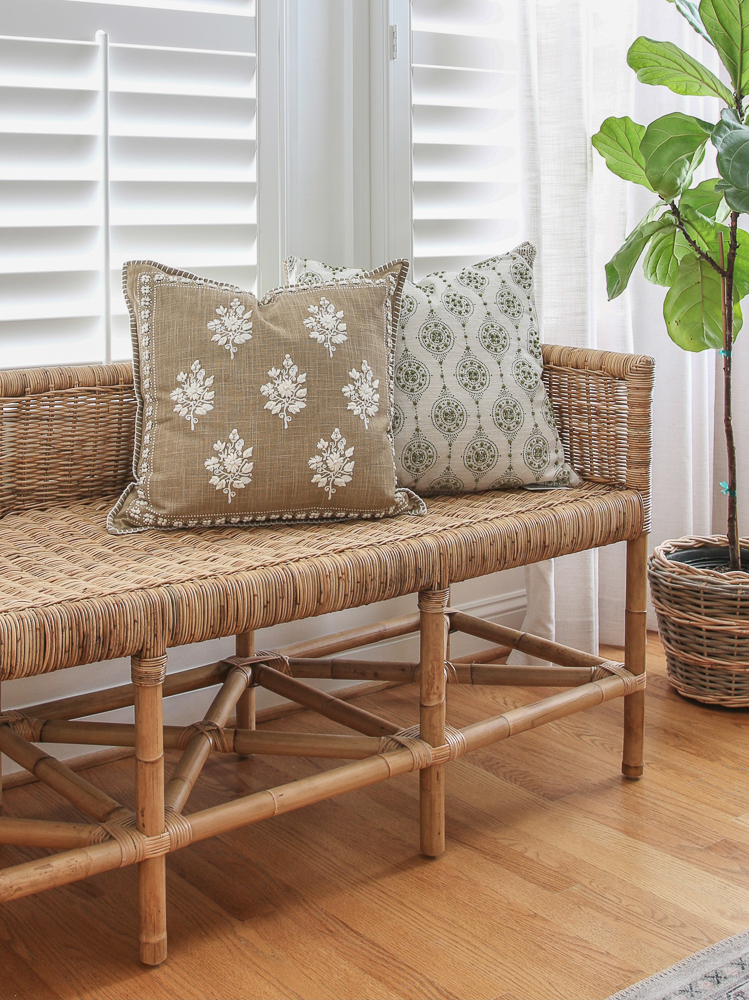 woven bench in front of window and hardwood floors