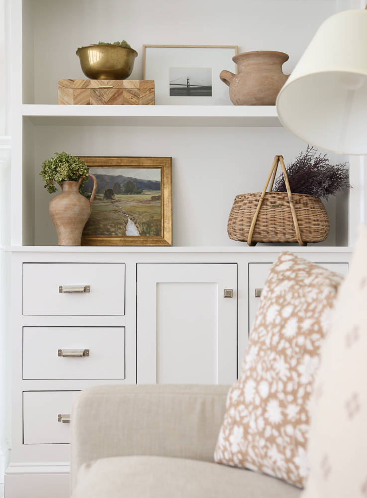 Shelf styling with fall decor. Dried flowers, pottery, and artwork.