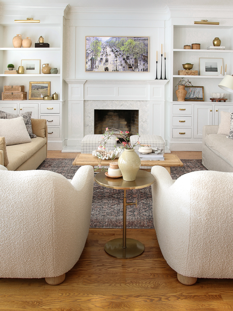 View of custom DIY builtin shelves showing how shelves are currently styled with greenery, brass and woven decorative objects. 