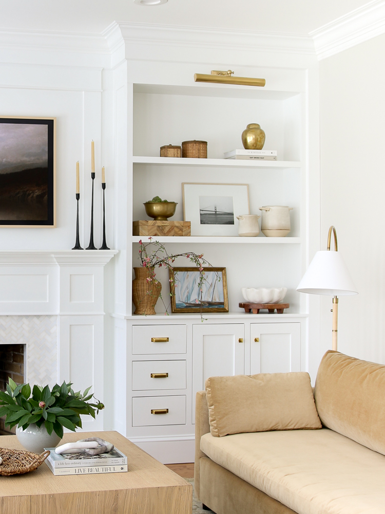 how to style shelves with items that coordinate with furniture and light fixtures in living room
