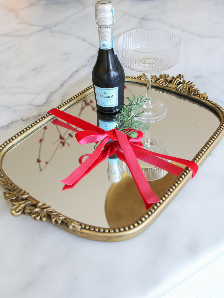 large gold tray with bottle of Prosecco and a fluted glass
