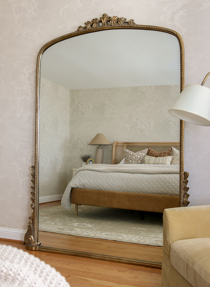 Seven foot gleaming primrose mirror propped against a wall in bedroom