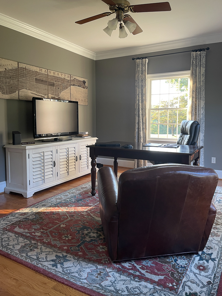 home office with white media cabinet and leather arm chair
