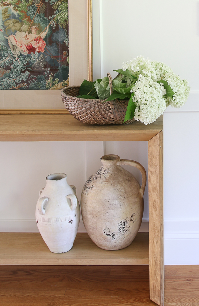 console table with basket of freshly cut white hydrangeas