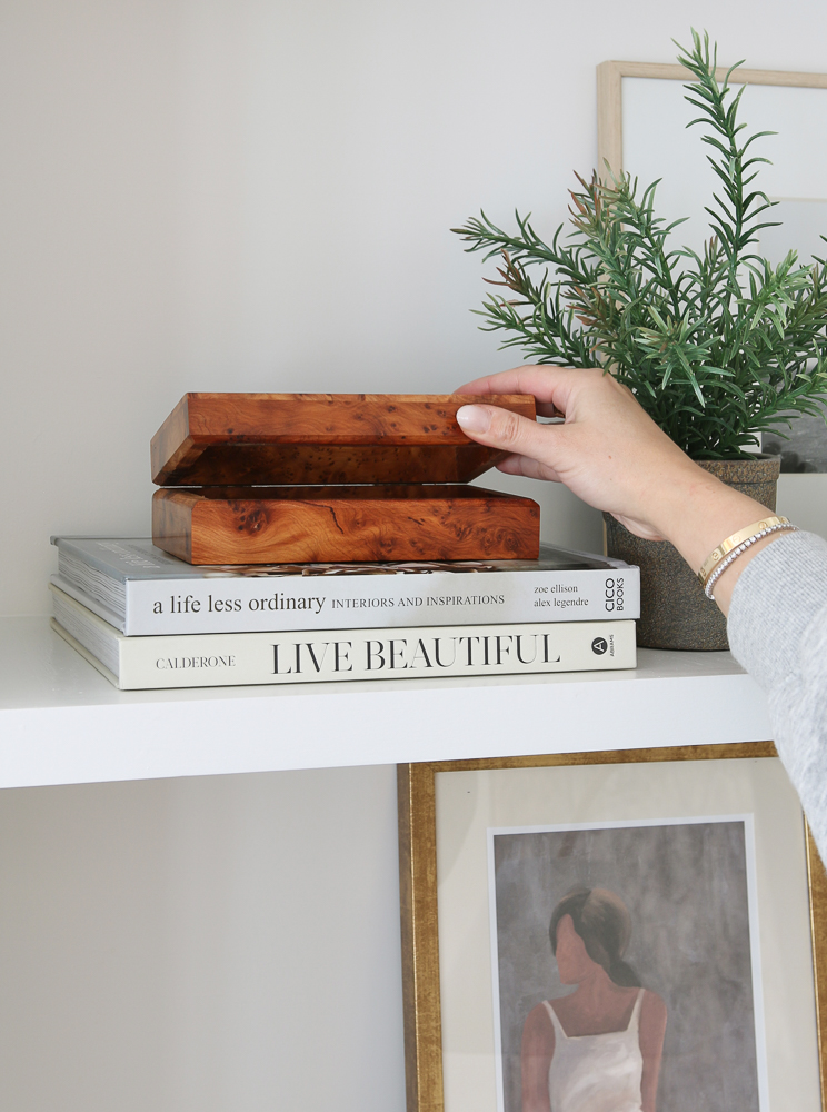 Stefana Silber demonstrates how to style a decorative box on stacked home decor books if given as home decor gifts
