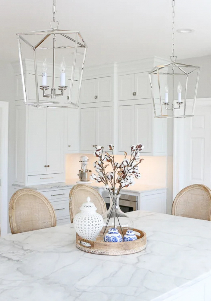 white kitchen with marble countertops, polished nickel lantern pendants, elegant and sophisticated home