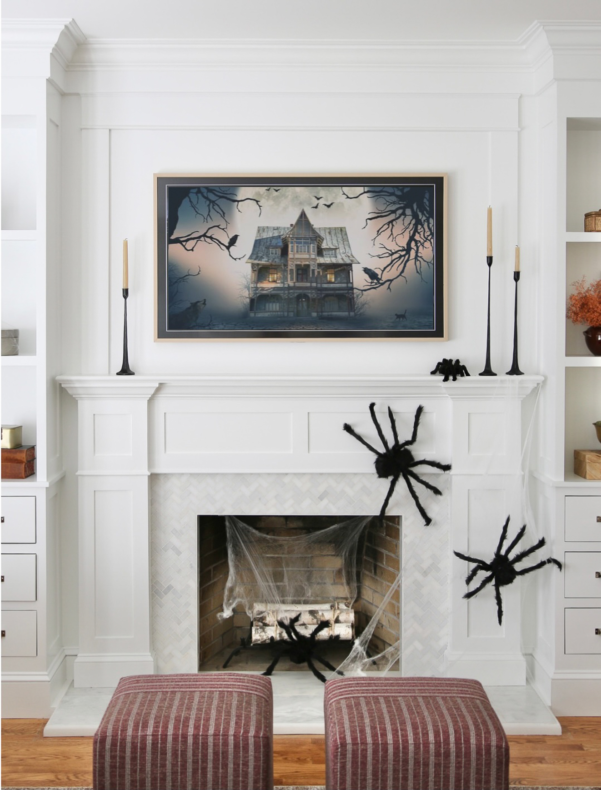 Halloween decor on fireplace with spooky house art on frame tv