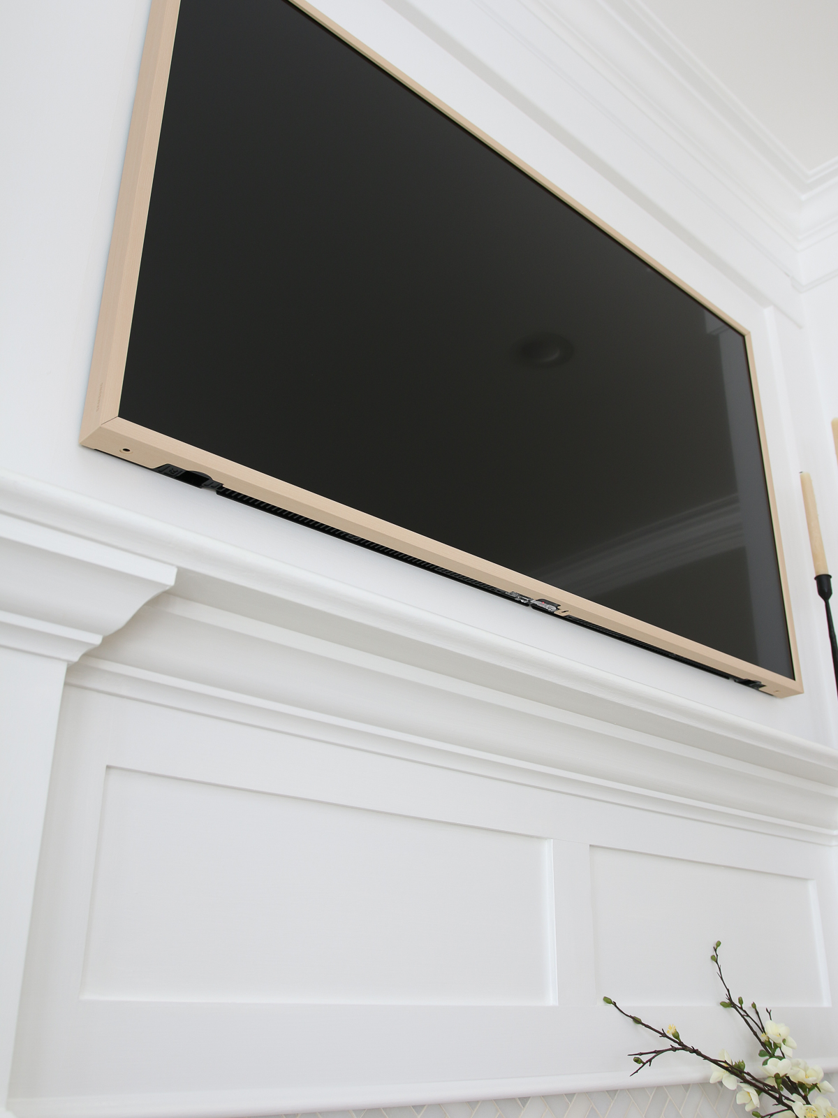 Frame tv with beige bezel view from below, openings for ventilation and signal transmission visible