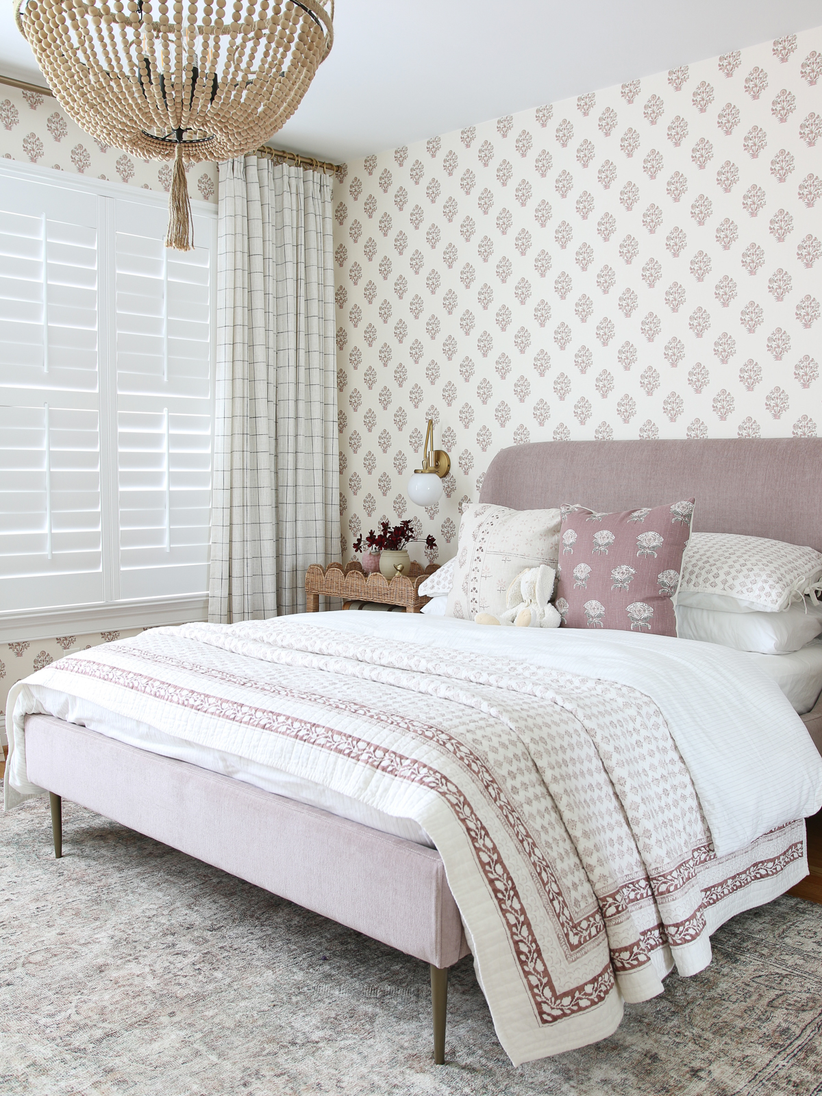 big girl bedroom ideas: block print wallpaper, mauve velvet upholstered bed, wicker nightstands, rope chandelier