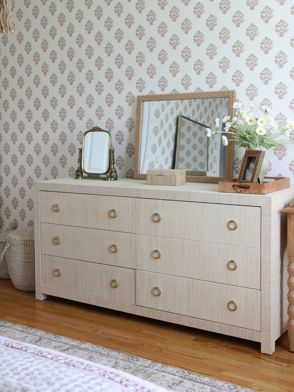 seagrass wrapped dresser with a gold vanity mirror, large woven rope mirror, burl wood tray, block print wallpaper