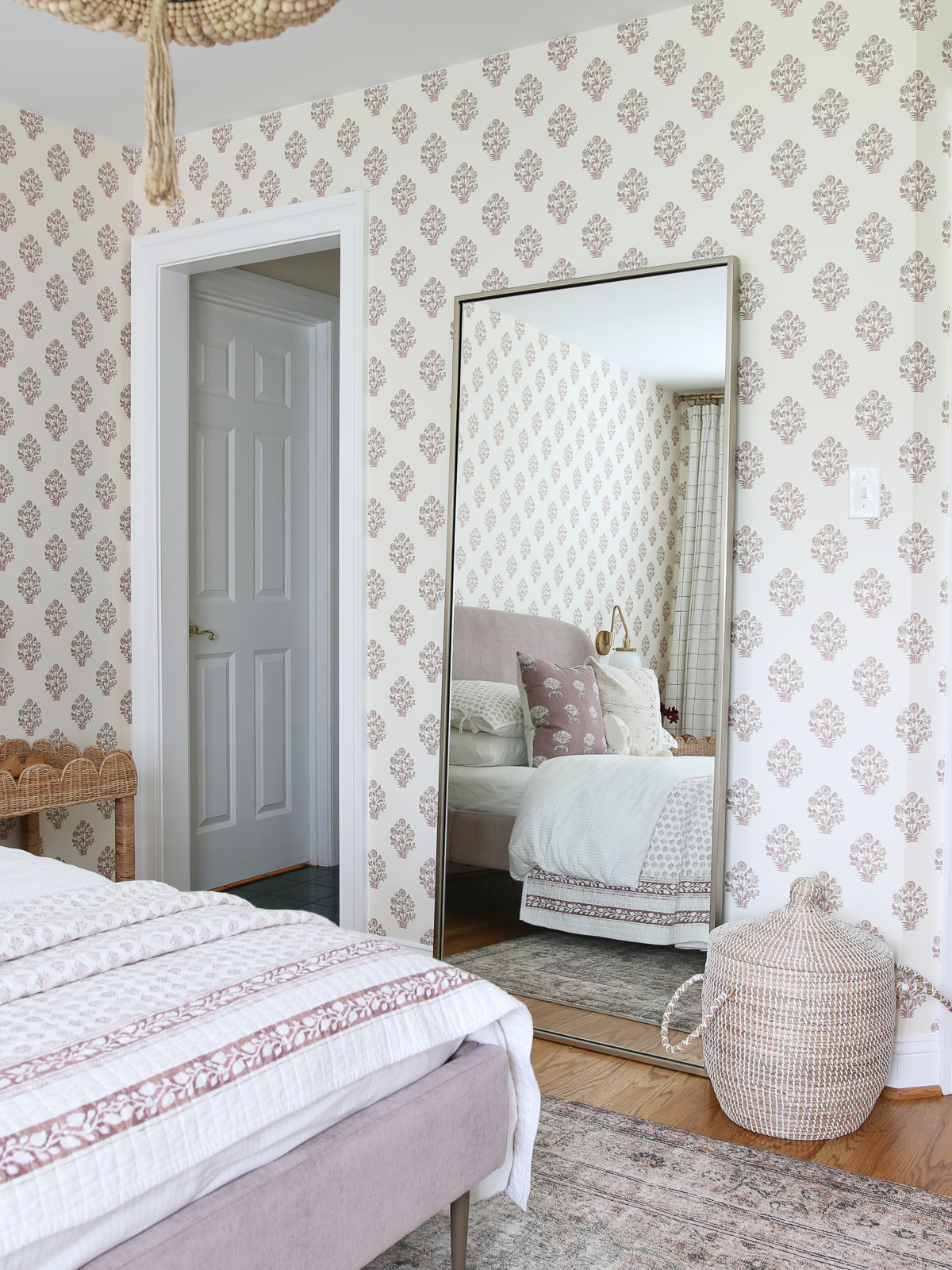 block print wallpaper in big girl bedroom with large metal leaning floor mirror and lidded basket