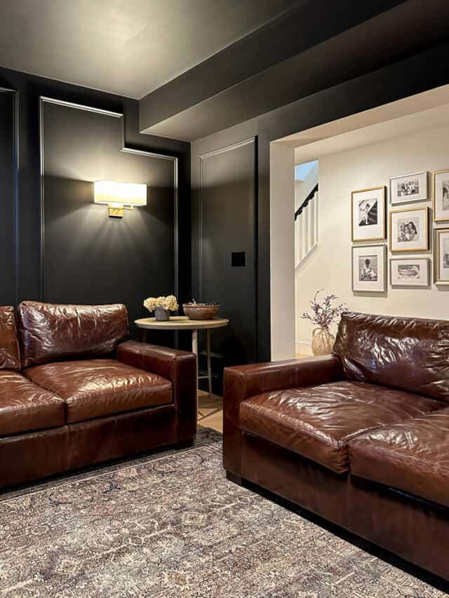 basement media room with black walls, two deep leather sofas from Casca Bay Furniture that look similar to Restoration Hardware