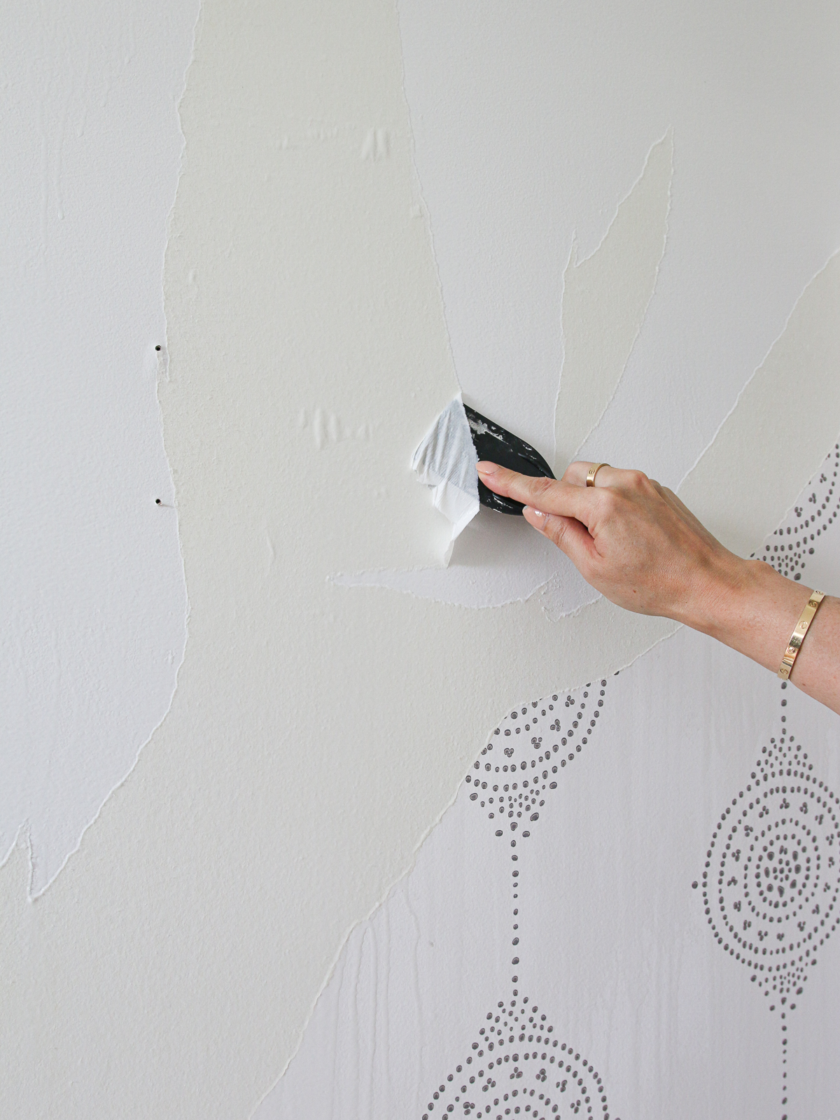 scraping old wallpaper with plastic spackle knife