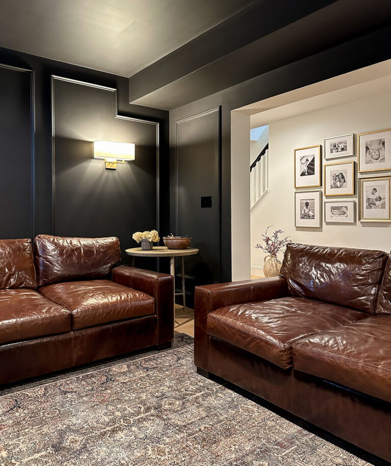 basement media room with black walls, two deep leather sofas from Casca Bay Furniture that look similar to Restoration Hardware