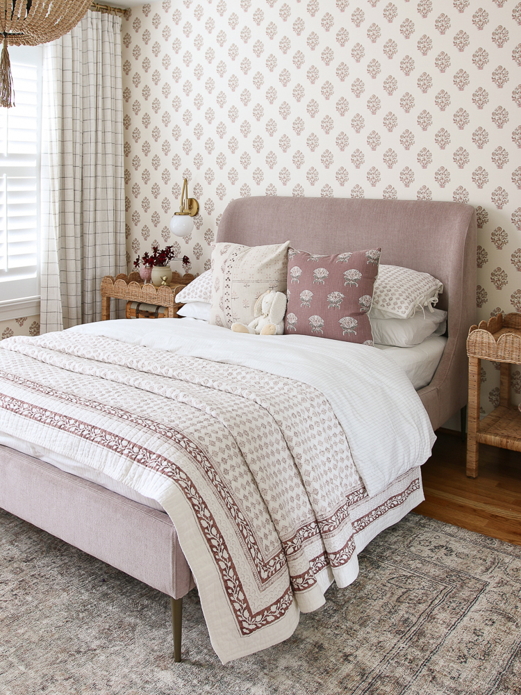 big girls bedroom with vintage wallpaper from North and Finch, mauve West Elm velvet bed, block print quilt, wicker Serena & Lily side tables