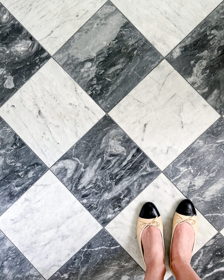 person standing on gray and white marble checkerboard floor