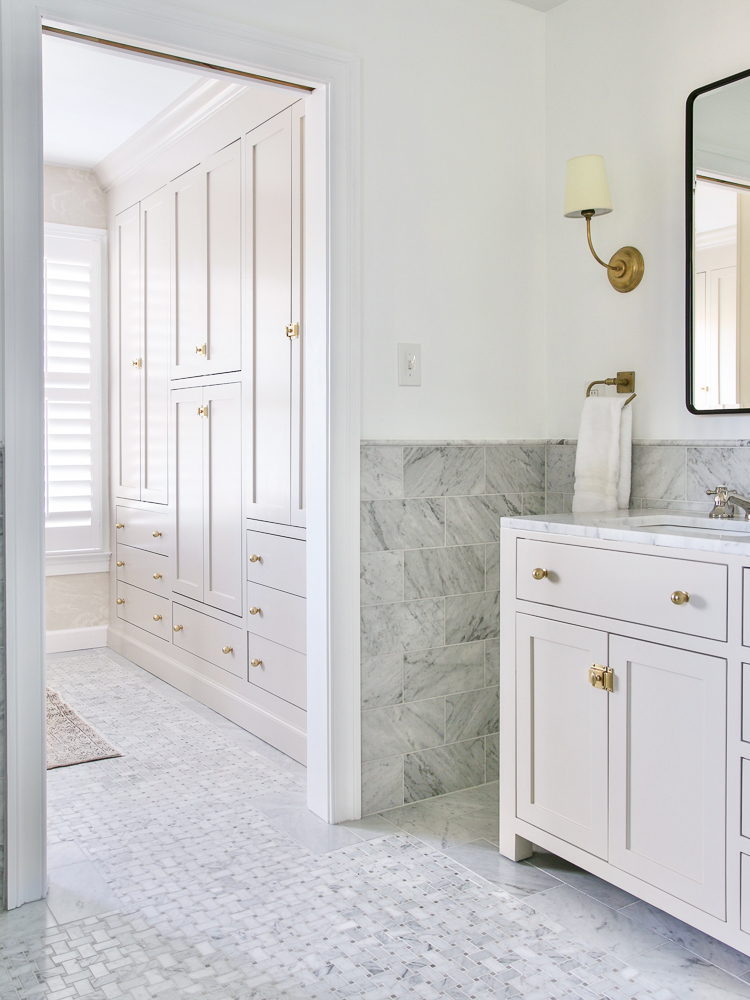 marble and mixed metal  bathroom design with a mixture of brass and polished nickel elements, brass cabinet hardware and lighting