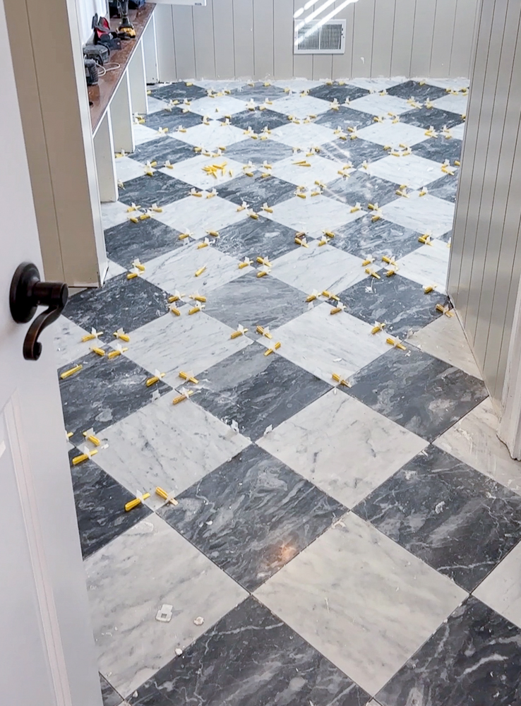 checkerboard floor tiles with level spacers to keep tiles equidistant apart and level