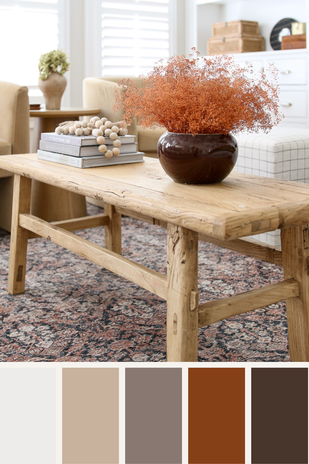 living room with fall color palette, wood coffee table with fall florals, coffee table books and wood beads in fall colors