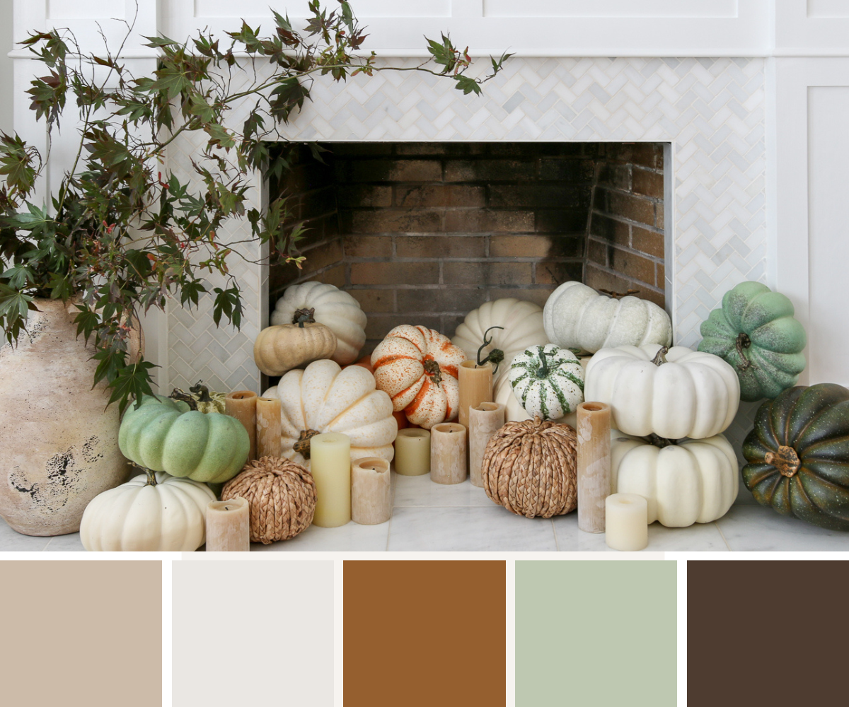 fall decor in fireplace, assorted pastel pumpkins, candles, artisan vase with foraged fall branches, marble tile fireplace surround 