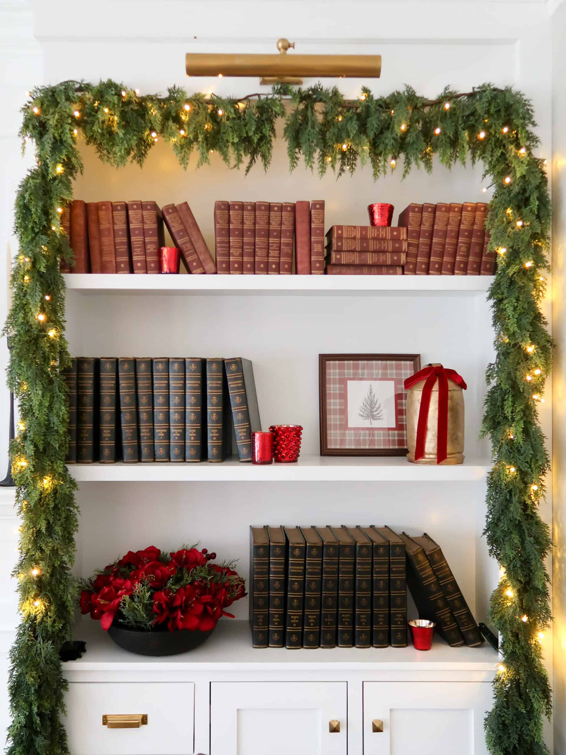 garland over a bookshelf, ralph laurnen style Christmas decor