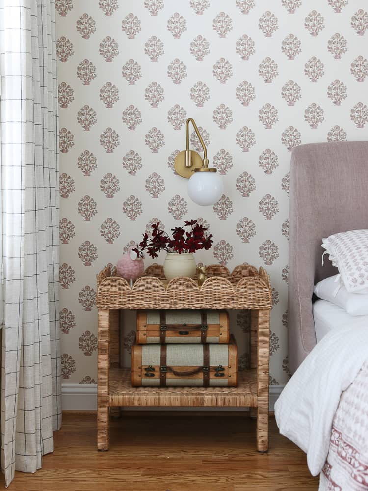 girls room with block print wallpaper to refresh the space, scalloped wicker side table mauve velvet bed