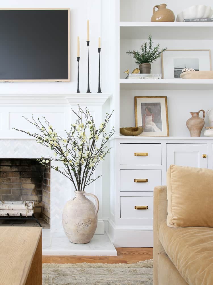 living room with built in cabinets and shelves on the side of the fireplace, shelf decor