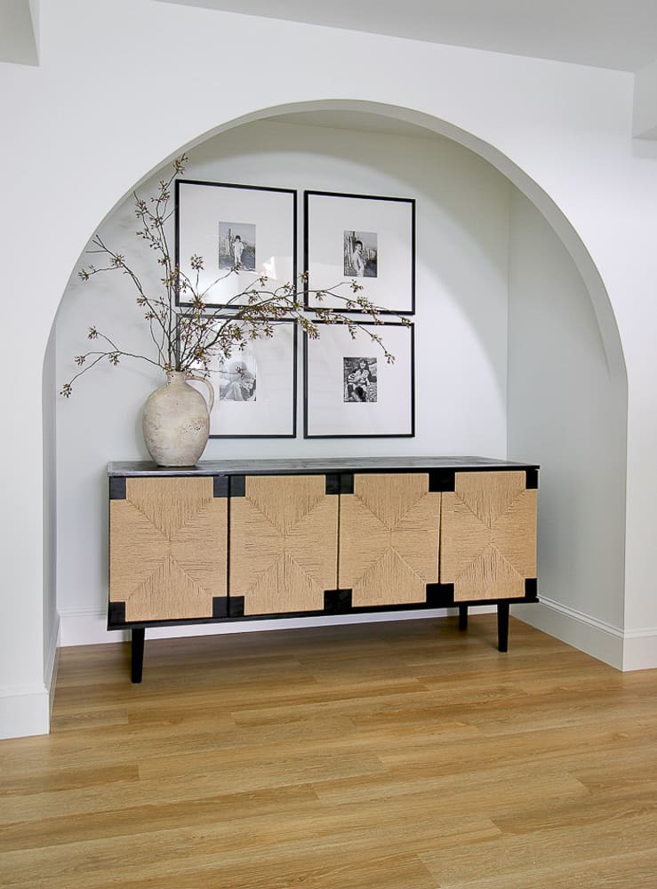 Arched niche in basement painted white, rushed cabinet, gallery wall